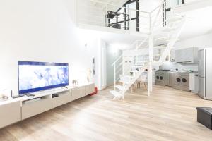 een woonkamer met een grote tv en een trap bij Fondazione Prada Exclusive Detached Loft - Top Collection in Milaan