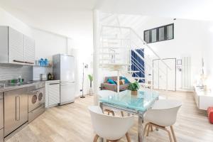 een keuken en een woonkamer met een glazen tafel en stoelen bij Fondazione Prada Exclusive Detached Loft - Top Collection in Milaan