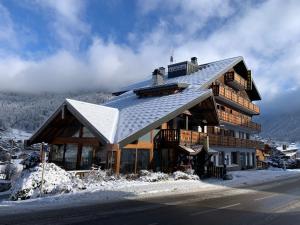 a large wooden house on top of a mountain at Hotel Le Concorde in Morzine