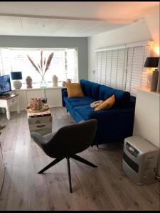 - un salon avec un canapé bleu et une chaise dans l'établissement De Bosuil, à Eext