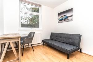 a living room with a couch and a table at Bright Guest House in Hackney in London