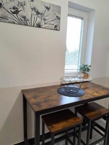a dining room table with two stools and a window at Cozy Town Center Retreat in Komárno