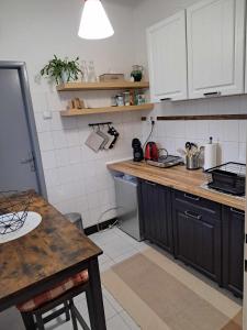 uma cozinha com armários pretos e uma mesa em Cozy Town Center Retreat em Komárno