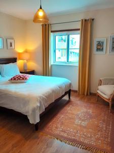 ein Schlafzimmer mit einem großen Bett und einem Fenster in der Unterkunft Palmeiras Apartement - T1 com Piscina in Baleal