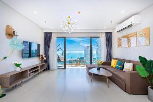 a living room with a couch and a large window at The Song Apartment - Căn Hộ The Sóng - Mai Villa Vũng Tàu in Vung Tau