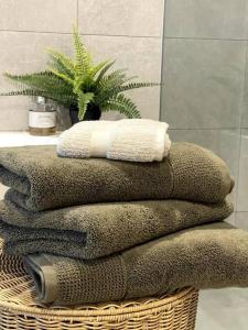 - une pile de serviettes sur un panier dans la salle de bains dans l'établissement Luxury Apartment in Shell Cove, à Shellharbour