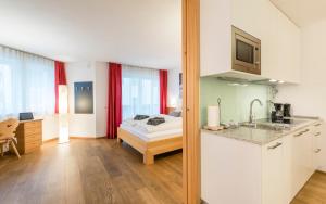 eine Küche und ein Schlafzimmer mit einem Bett in einem Zimmer in der Unterkunft Avita - suites to relax in St. Ulrich in Gröden