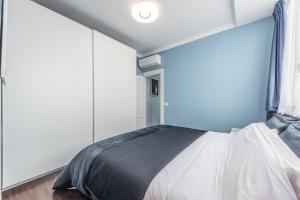 a bedroom with a bed with a blue wall at Sky Apartments in Durrës
