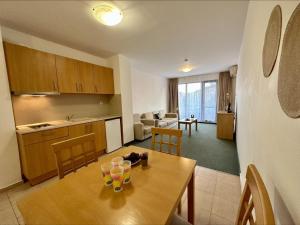 a kitchen and living room with a wooden table and chairs at Menada Apartments in Marina Cape in Aheloy
