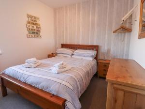 1 dormitorio con 1 cama con toallas en The Old Smithy en Morpeth