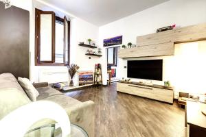 sala de estar con sofá y TV de pantalla plana en Geppi's Apartments, en Florencia