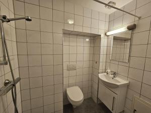 een witte badkamer met een toilet en een wastafel bij Løkka Express Rooms in Oslo