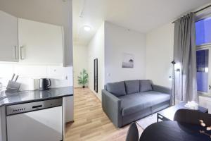 een keuken en een woonkamer met een bank bij Løkka Express Rooms in Oslo