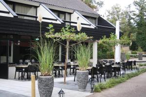 un restaurante con mesas y sillas frente a un edificio en Bosrijke vakantiewoning en Lochem