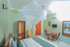 a bedroom with a bed and a chandelier at Fort Suites in Fort Portal