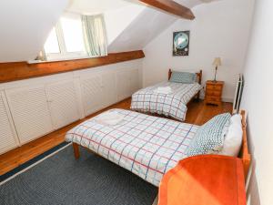 a bedroom with two beds and a window at The Bookshelf in Oystermouth