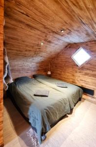 um quarto com uma cama num chalé de madeira em Cozy Cabin Styled Loft em Kiruna