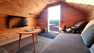 a living room with a couch and a tv and a table at Cozy Cabin Styled Loft in Kiruna