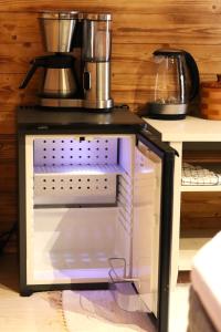 a microwave with a coffee pot on top of it at Cozy Cabin Styled Loft in Kiruna