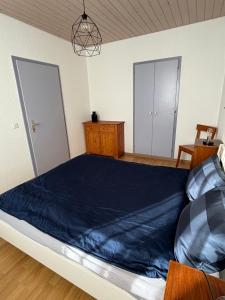 a bedroom with a large bed with a blue blanket at Croix 1 in Le Noirmont