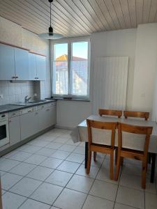 uma cozinha com uma mesa e duas cadeiras em Croix 1 em Le Noirmont