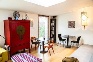 布格奈的住宿－Le nid du massereau，客厅配有红色橱柜和桌子
