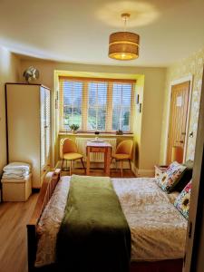1 dormitorio con cama, mesa y ventanas en Rosegarth Bed and Breakfast en Marton