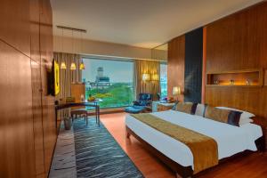 a hotel room with a bed and a desk at O Hotel Pune in Pune +112 photos