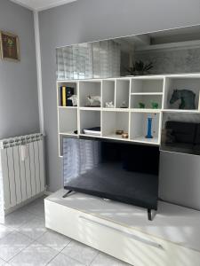 a living room with white shelves and a tv at Appartamento Seriate/Confine Bergamo in Seriate