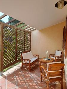 eine Terrasse mit Stühlen, einem Tisch und einem Zaun in der Unterkunft Casa vacanze sole e mare in Porto Pino