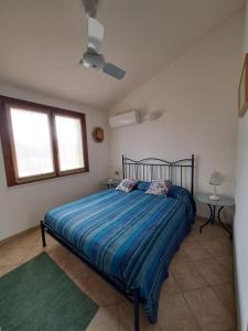 ein Schlafzimmer mit einem Bett, zwei Tischen und einem Fenster in der Unterkunft Casa vacanze sole e mare in Porto Pino