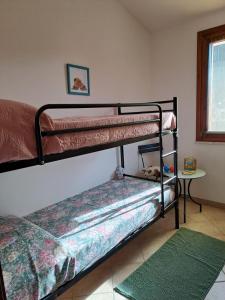 2 Etagenbetten in einem Zimmer mit grünem Teppich in der Unterkunft Casa vacanze sole e mare in Porto Pino