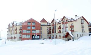 un grupo de edificios con nieve delante de ellos en New Gudauri Apartment, en Gudauri
