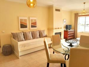 ein Wohnzimmer mit einem Sofa und einem Tisch in der Unterkunft Palmeiras Apartement - T1 com Piscina in Baleal