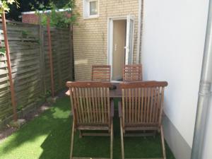 a patio with three chairs and a table on a porch at Ferienwohnung Lützowstrasse 2 in Lübeck