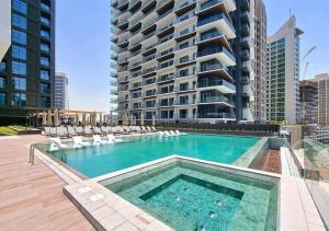 uma piscina com cadeiras e um grande edifício em NEW Studio! With Epic Amenities 8 min to DubaiMall em Dubai