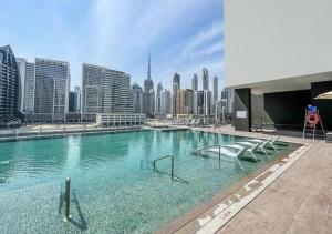 uma grande piscina com vista para a cidade em NEW Studio! With Epic Amenities 8 min to DubaiMall em Dubai