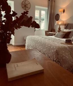 Un dormitorio con 2 camas y una mesa con un libro. en Maison du Lierre Bordeaux Centre ville en Burdeos