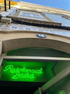 a neon sign in the window of a retail store at A Beira Hostel in Aveiro