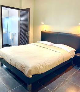 a bedroom with a large bed with a large white sheets at L'Eskale Guyane in Montjoly