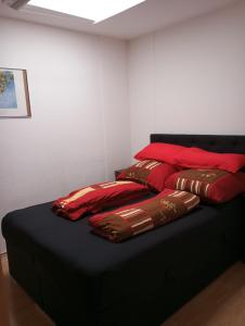a bed with red and brown pillows on it at Ferienwohnung neben HBF in Gera