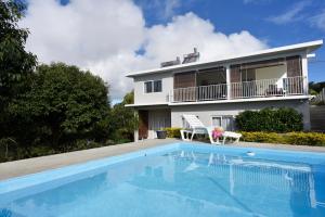 a house with a swimming pool in front of a house at Rodrigues Holiday Family Villa Zourit in Rodrigues Island