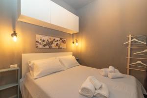 um quarto com uma cama com toalhas em White Sand House em Marina di Portisco