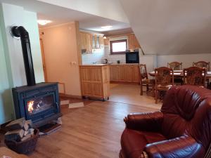 a living room with a fireplace and a kitchen at Apartman Centar Fužine in Fužine