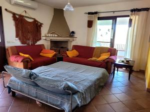 een woonkamer met 2 banken en een bed bij SAS DOMOS De BADDE MANNA in Torpè