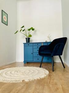 una silla azul y una cómoda azul en una habitación en Mieszkanie na Tumskiej, en Płock