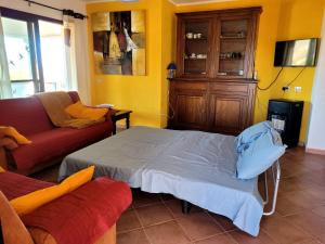 een woonkamer met een bed en een bank bij SAS DOMOS De BADDE MANNA in Torpè