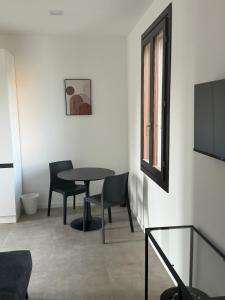 Habitación con mesa, sillas y TV. en Ambra House, en Trezzano sul Naviglio