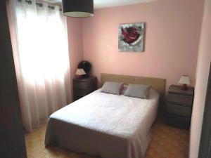 um quarto com uma cama numa parede cor-de-rosa em Les Locations de Lara I - T2 spacieux Loggia Parking privatif Près port, plage, Ile Loisirs em Cap d'Agde