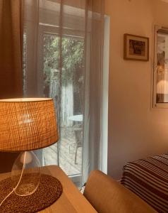 a lamp sitting on a table next to a window at Maison du Lierre Bordeaux Centre ville in Bordeaux